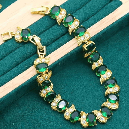 Luxurious 18K gold plated bracelet adorned with vibrant green oval gemstones and shimmering cubic zirconia.