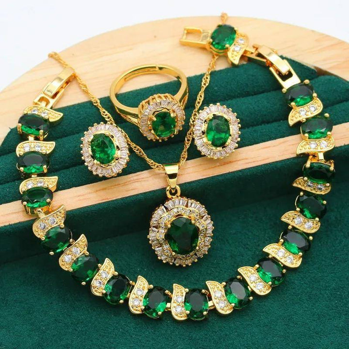 Elegant 18K gold plated jewelry set with green oval gemstones and sparkling cubic zirconia accents. Includes a necklace, bracelet, earrings, and ring.