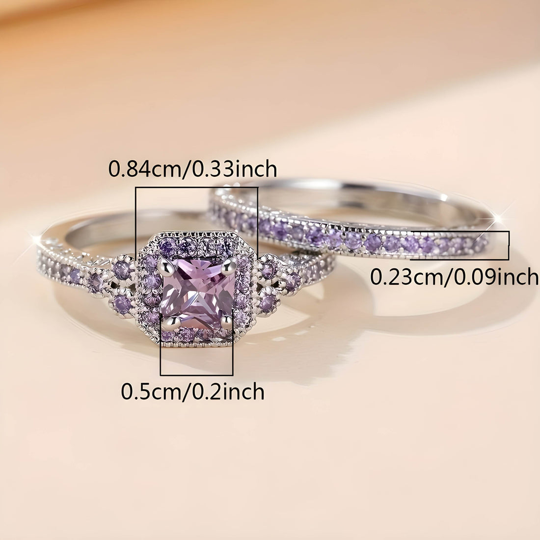 Two stylish promise rings for women: one ring has a pink square-cut gemstone in the center, surrounded by small clear crystals, while the other ring has a matching band of small clear crystals.