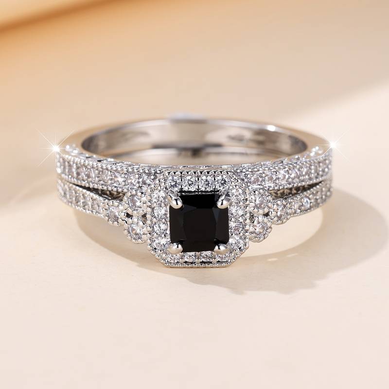 A close-up view of a stunning promise ring for women featuring a square black gemstone set in a silver band. The band is adorned with sparkling small diamonds, enhancing the elegance of the ring.