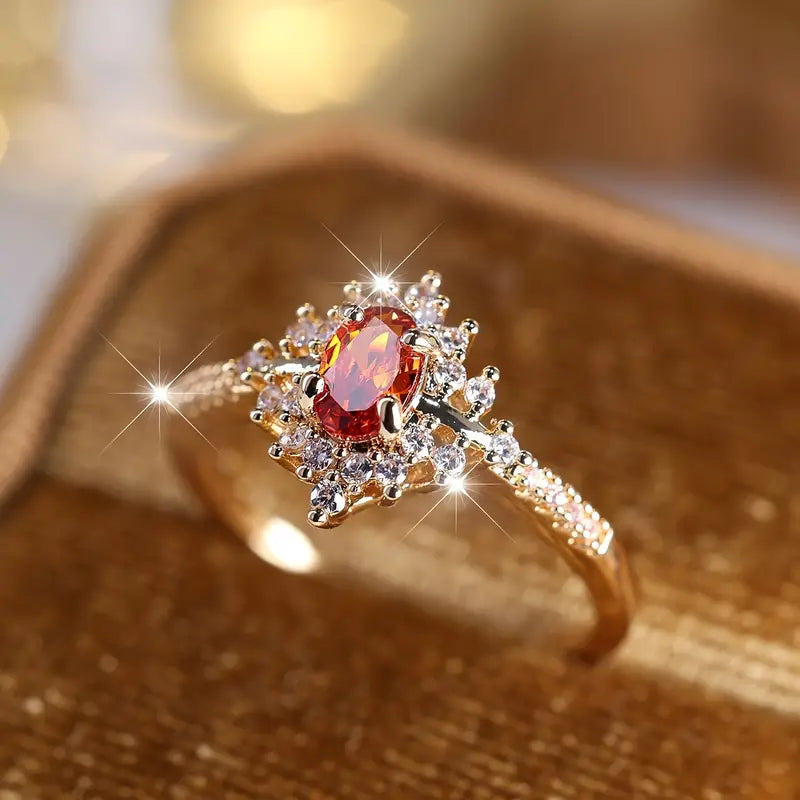 A gold-plated ring featuring a vibrant orange gemstone, rotating to showcase its intricate design and polished finish. The ring is highlighted against a simple background, emphasizing its elegance and the brilliance of the gemstone